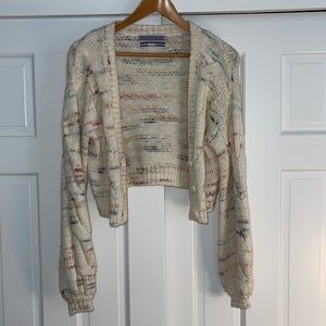 UO cream short cardigan/ sweater with light colored pattern.
